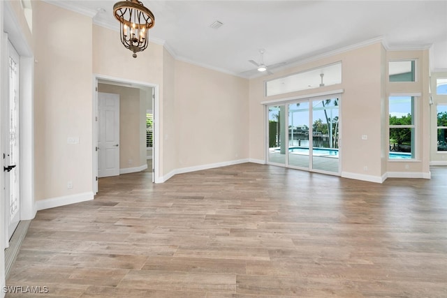 spare room featuring crown molding, light hardwood / wood-style flooring, and ceiling fan with notable chandelier