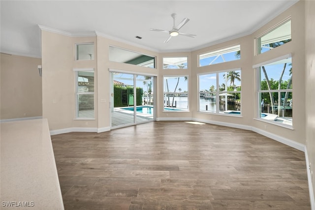 unfurnished living room featuring hardwood / wood-style floors, ceiling fan, and a healthy amount of sunlight