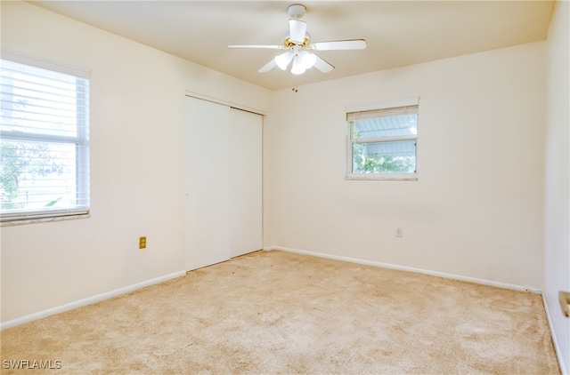 carpeted empty room with plenty of natural light and ceiling fan