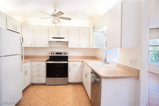 kitchen with custom exhaust hood, ceiling fan, appliances with stainless steel finishes, light tile patterned floors, and sink