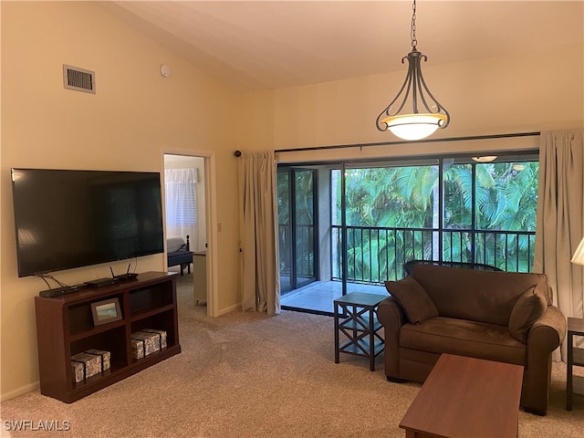 carpeted living room with high vaulted ceiling