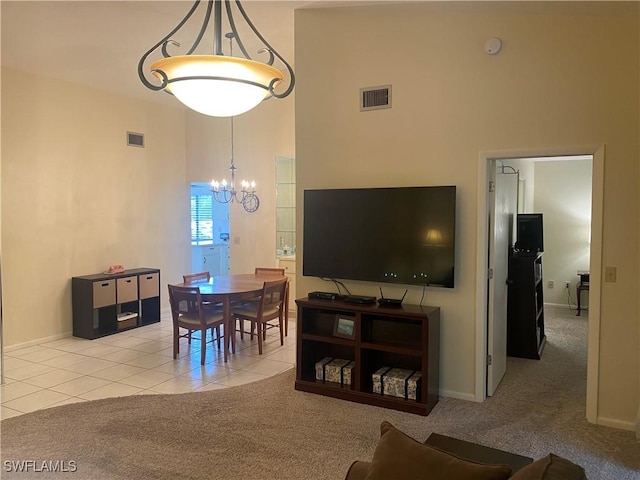 dining area featuring light tile patterned floors, a high ceiling, visible vents, and light colored carpet