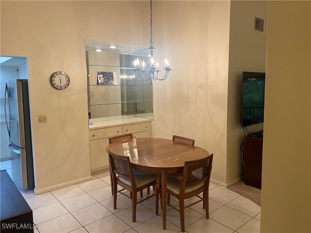 dining area with light tile patterned floors, baseboards, visible vents, and an inviting chandelier