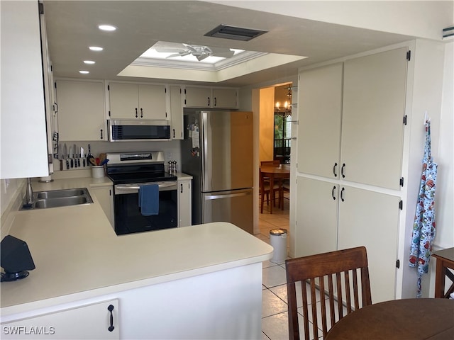 kitchen featuring stainless steel appliances, a skylight, sink, a raised ceiling, and light tile patterned floors