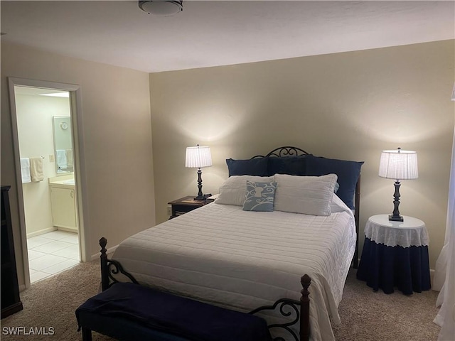 bedroom with light tile patterned flooring, ensuite bathroom, and light colored carpet