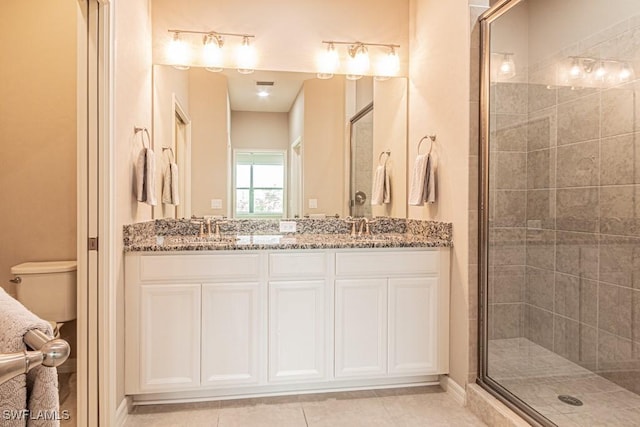 full bathroom featuring a sink, a shower stall, toilet, and double vanity