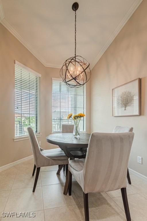 dining space featuring an inviting chandelier, ornamental molding, baseboards, and light tile patterned floors