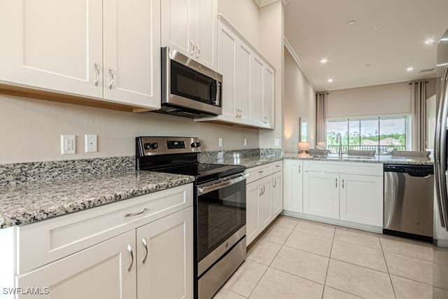 kitchen featuring appliances with stainless steel finishes, white cabinets, ornamental molding, and sink