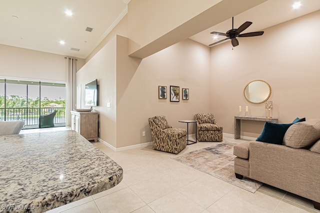 tiled living room with ceiling fan and a towering ceiling