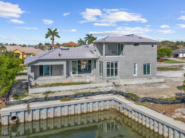 back of house with a patio and a water view