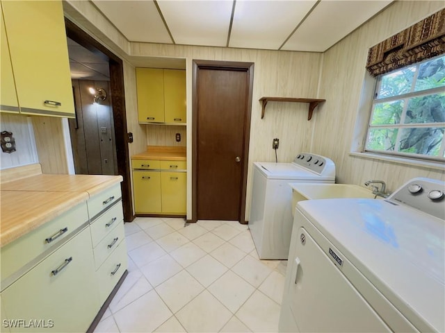 washroom with cabinets, washing machine and dryer, and wooden walls