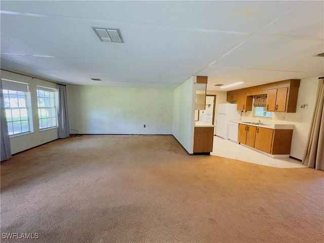 unfurnished living room featuring light colored carpet