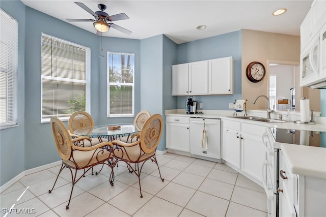 kitchen featuring white appliances, sink, ceiling fan, white cabinets, and light tile patterned flooring