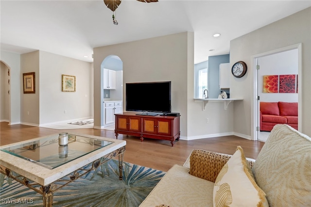 living room featuring hardwood / wood-style floors and ceiling fan