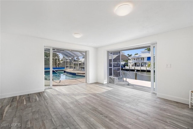 spare room with wood-type flooring and a water view