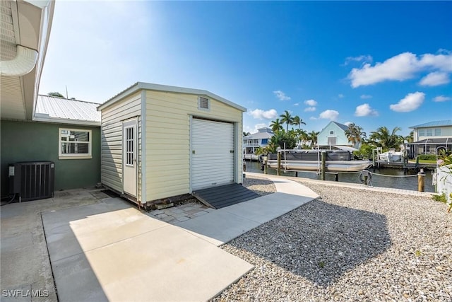 view of outbuilding with cooling unit and a water view