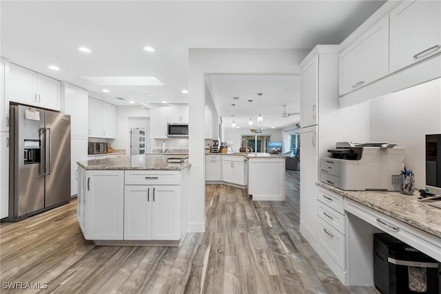 kitchen featuring a center island, stainless steel appliances, and white cabinetry