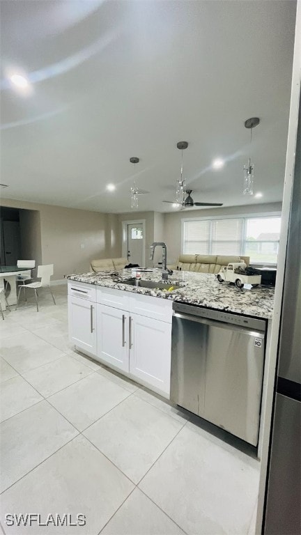 kitchen featuring light stone counters, ceiling fan, white cabinetry, stainless steel dishwasher, and sink