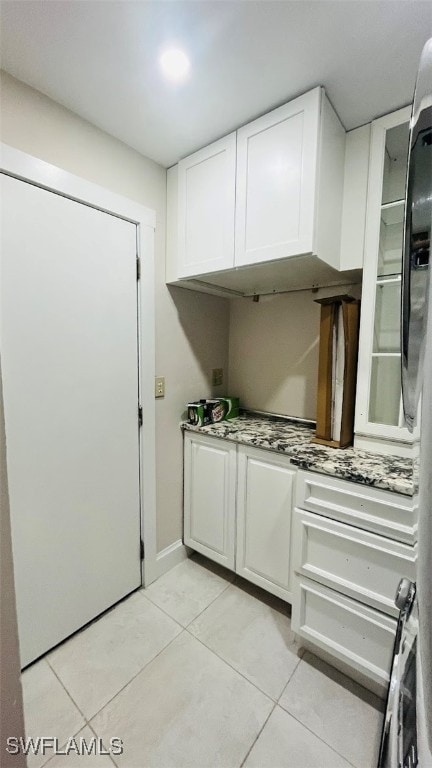 kitchen with light tile patterned flooring and white cabinetry