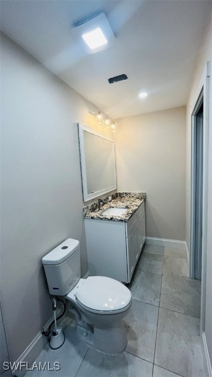 bathroom featuring vanity, toilet, and tile patterned flooring