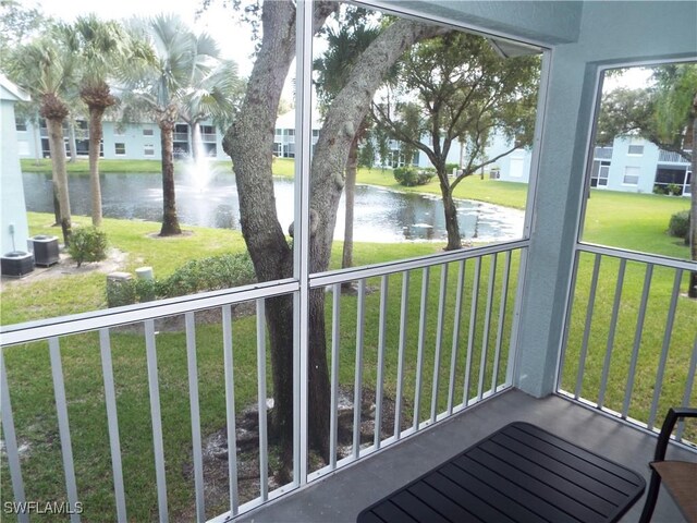 unfurnished sunroom featuring a water view