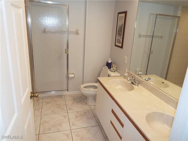 bathroom featuring a shower with door, vanity, and toilet