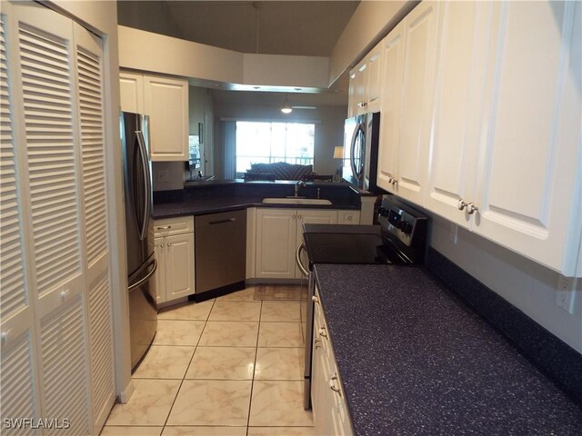 kitchen featuring stainless steel appliances, sink, light tile patterned floors, white cabinets, and kitchen peninsula