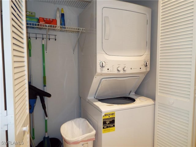 clothes washing area with stacked washing maching and dryer