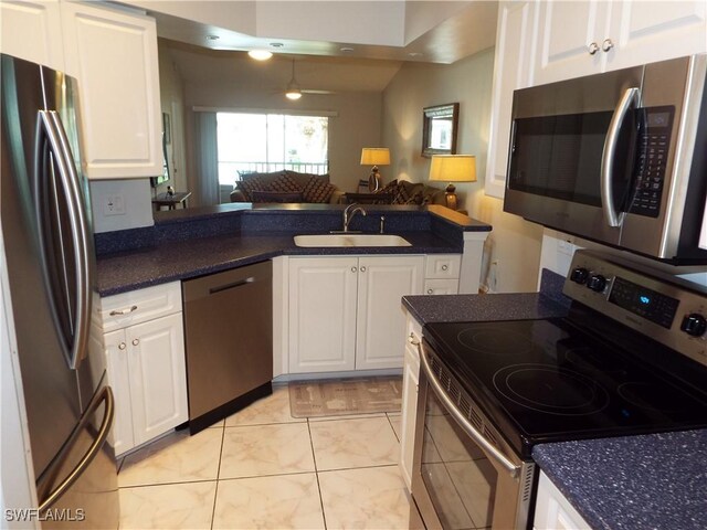 kitchen featuring appliances with stainless steel finishes, white cabinetry, sink, ceiling fan, and kitchen peninsula