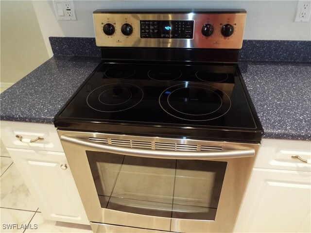 room details featuring white cabinetry and stainless steel electric stove