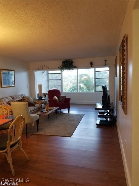 living room with hardwood / wood-style floors and a textured ceiling