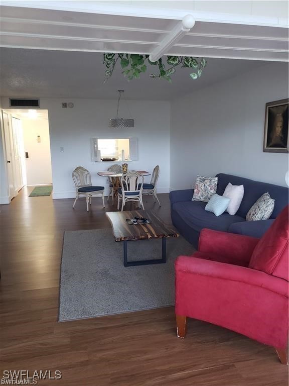 living room with beamed ceiling and hardwood / wood-style floors