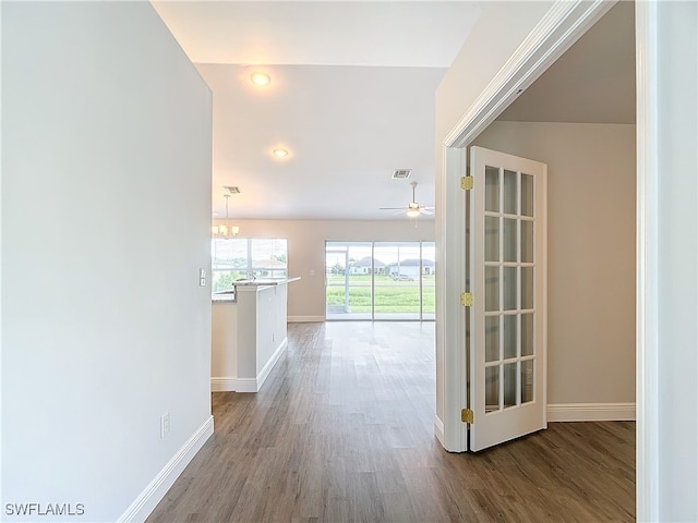 hall with a notable chandelier and hardwood / wood-style flooring