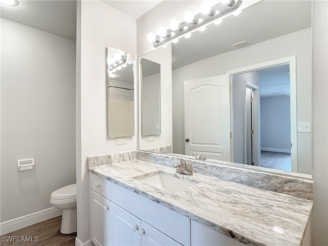 bathroom featuring vanity, toilet, and hardwood / wood-style floors