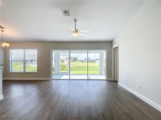 unfurnished room featuring dark wood-type flooring and ceiling fan with notable chandelier