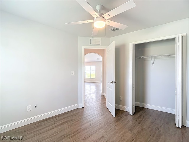 unfurnished bedroom featuring hardwood / wood-style floors, a closet, and ceiling fan