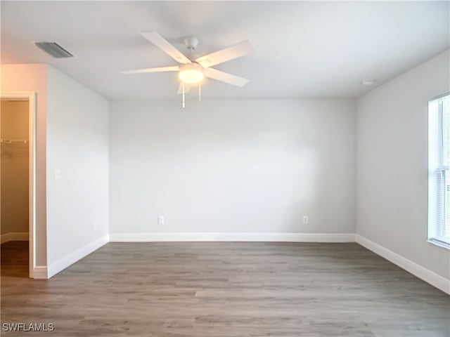 empty room featuring hardwood / wood-style flooring, ceiling fan, and a wealth of natural light