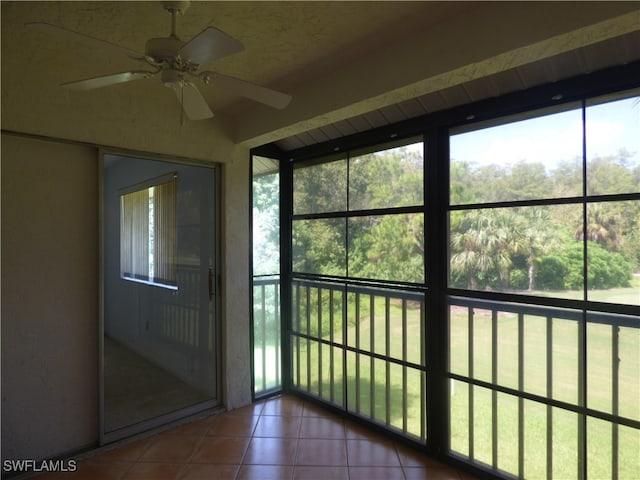 doorway featuring tile patterned floors and ceiling fan