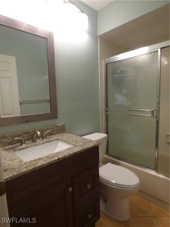 full bathroom featuring tile patterned flooring, toilet, vanity, and enclosed tub / shower combo