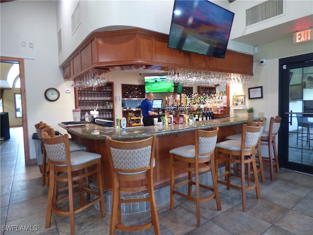 bar with a high ceiling and tile patterned floors