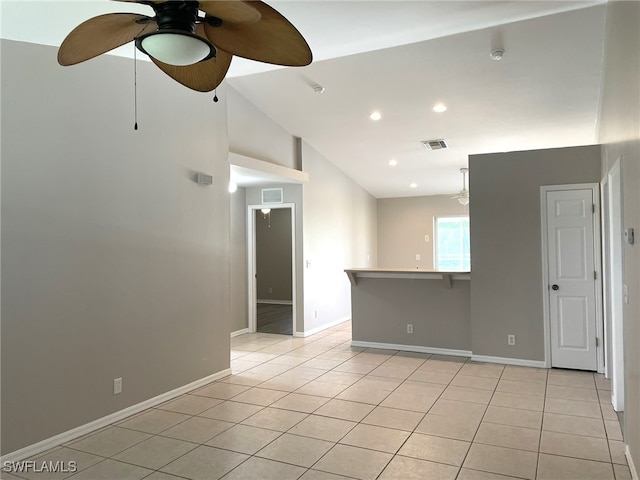 empty room featuring ceiling fan, light tile patterned flooring, and lofted ceiling