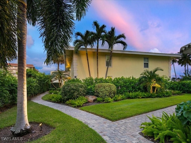 property exterior at dusk with a yard