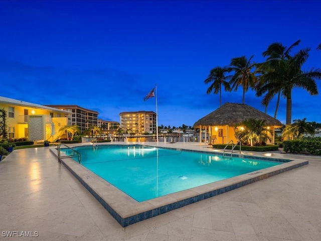 pool at dusk featuring a patio