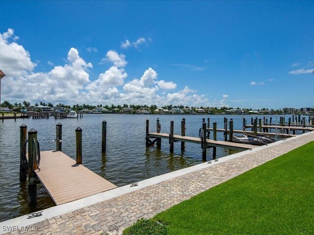 view of dock featuring a water view and a yard