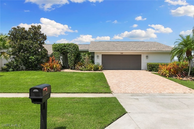 ranch-style house featuring a front yard and a garage