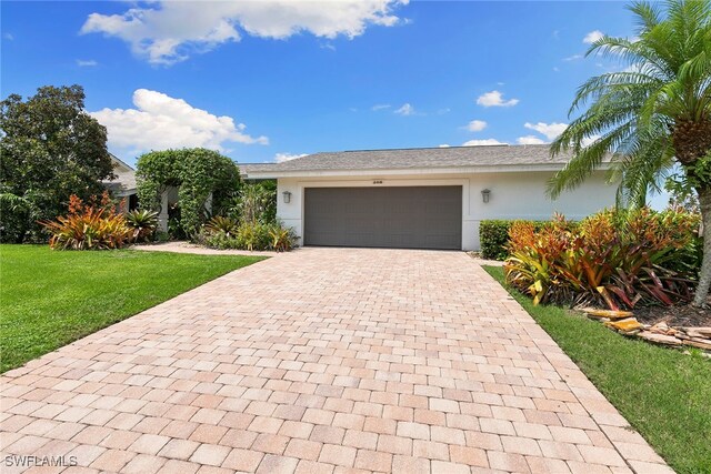 single story home with a front yard and a garage