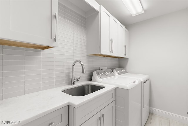 washroom featuring cabinets, light tile patterned flooring, washer and dryer, and sink