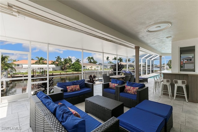 exterior space featuring a bar, a water view, and an outdoor living space