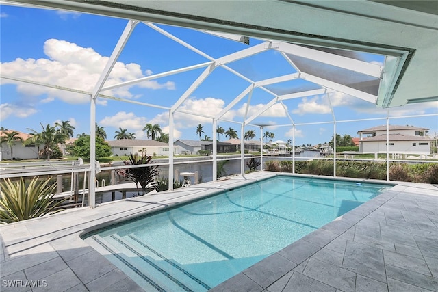 view of pool featuring a lanai, a water view, and a patio area