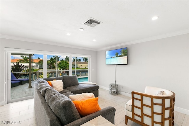 living room featuring a wealth of natural light, a water view, and crown molding